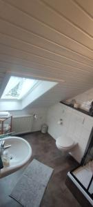 a bathroom with a white toilet and a sink at Ferienwohnung 2 - Leopold in Cuxhaven