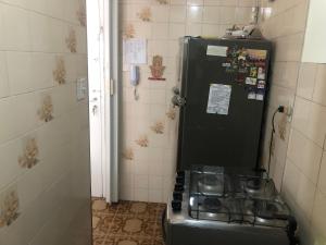 a kitchen with a stove and a refrigerator at Pé na areia em Santos in Santos