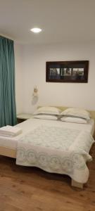 a bedroom with a large bed with a green curtain at Theo House in Sibiu