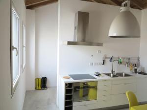 a white kitchen with a sink and a stove at Baía das Caldeirinhas in Horta