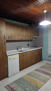 eine Küche mit Holzschränken und einem weißen Geschirrspüler in der Unterkunft Kozalak Villa in Sapanca