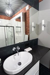 y baño con lavabo blanco y espejo. en Labo Apartment Metro Młociny en Varsovia