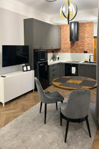 uma cozinha com uma mesa e duas cadeiras e uma televisão em Labo Apartment Metro Młociny em Varsóvia