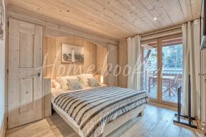 a bedroom with a bed and a balcony at Appartement Amour in Megève