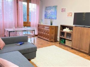 een woonkamer met een bank en een flatscreen-tv bij Camilla Florence Apartment in Florence