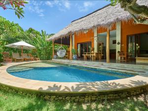 a villa with a swimming pool in front of a house at Villa Adi in Amed