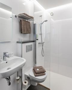 een witte badkamer met een wastafel en een douche bij Hotel Olympia in Bruges in Brugge