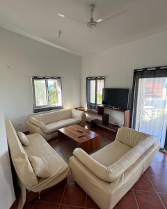uma sala de estar com sofás e uma televisão de ecrã plano em Villa GÊMEO vue mer, piscine accès privé plage em Calheta Do Maio