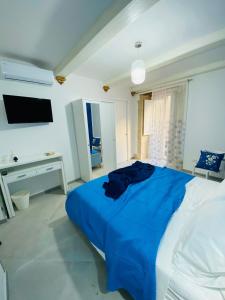 a bedroom with a blue bed and a tv at Casa 68 Ortigia in Syracuse