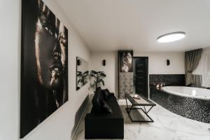 a bathroom with a tub and a large painting on the wall at Kiss Apartment in Šilutė