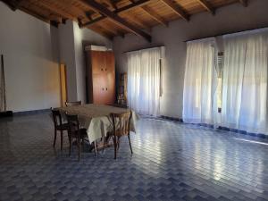 a table and chairs in a room with white curtains at Casa frente al mar Monte Hermoso in Monte Hermoso +17 photos