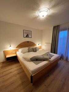 a bedroom with a large bed with a wooden headboard at LUSE Living in Maurach