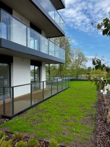 une vue extérieure d'un bâtiment avec une pelouse dans l'établissement Apartament Turkusowy - basen, sauna, klimatyzacja, à Dziwnów