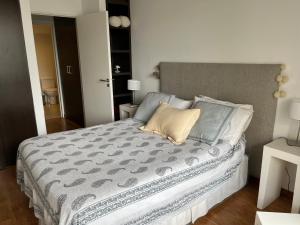 a bedroom with a large bed with a gray comforter at Ubicación Exclusiva en Palermo c/ Piscina in Buenos Aires