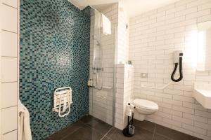 a bathroom with a shower with a toilet and a sink at Holiday Inn Calais - Centre Car Ferry by IHG in Calais +88 photos