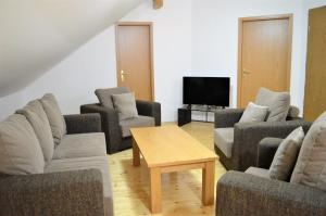 a living room with couches and a table and a tv at Mountain house Korab Trnica in Trnica