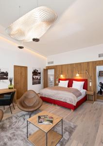 Hotel Diamond Country Club في Atzenbrugg: غرفة نوم مع سرير وغرفة معيشة