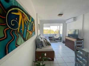 una sala de estar con una pintura en la pared en Apartamento edificio Cap Ferrat en la mansa Punta del Este, en Punta del Este