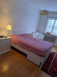 a bedroom with a bed and a desk and a window at Röda villan 