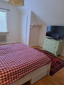 a bedroom with a bed and a tv and a dresser at Röda villan 