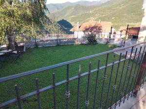 einen Balkon mit einem Zaun und einen Hof mit einem Haus in der Unterkunft Green House 2.0 in Pieve di Teco