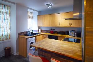 cocina con armarios de madera y mesa de madera en The Black Isle Retreat en Inverness