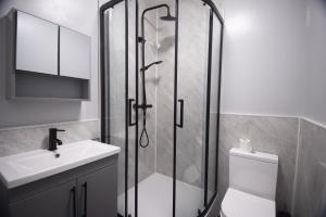 een badkamer met een douche, een toilet en een wastafel bij The Black Isle Retreat in Inverness