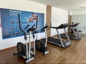 un gimnasio con 3 bicicletas estáticas en una habitación en Velutti Encantos do Mar, VISTA MAR, PREMIUM, PENHA, Beto Carrero World, en Penha