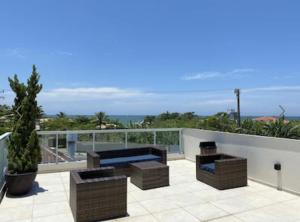 balcón con sofá y vistas al océano en Velutti Encantos do Mar, VISTA MAR, PREMIUM, PENHA, Beto Carrero World, en Penha
