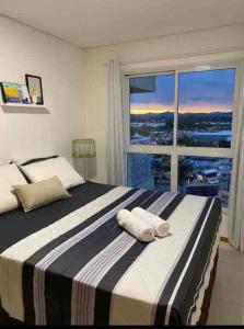 1 dormitorio con 1 cama grande y ventana grande en Velutti Encantos do Mar, VISTA MAR, PREMIUM, PENHA, Beto Carrero World, en Penha