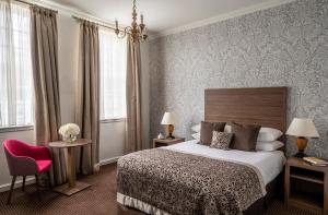 una camera d'albergo con letto e sedia rossa di Brandshatch Place & Spa ad Ash