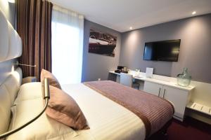 Habitación de hotel con cama y TV en Hôtel du Golf Saint Lazare, en Limoges