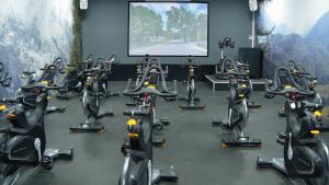a gym with a bunch of exercise bikes in front of a screen at Brandshatch Place Hotel & Spa in Dartford