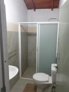 a bathroom with a shower and a toilet and a sink at Mini Jungle Canopy Udawalawe in Udawalawe