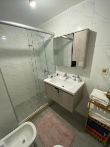 y baño blanco con lavabo y ducha. en Apartamento edificio Cap Ferrat en la mansa Punta del Este, en Punta del Este