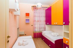 2 camas en una habitación con armarios coloridos en Alessandria Central Apt 10min walk Central Station, en Alessandria