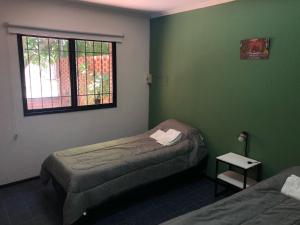 2 camas en una habitación con paredes verdes y ventana en La Casa San Rafael en San Rafael