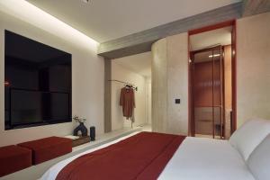 a bedroom with a large bed and a television at The Newel Metaxourgeio in Athens