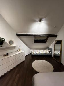 a white room with a bed and a mirror at Loft pour escapade en amoureux ou en famille. in Chaudfontaine
