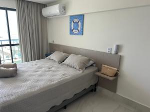 1 dormitorio con cama y ventana en Porto Galinhas frente mar Mikonos en Ipojuca