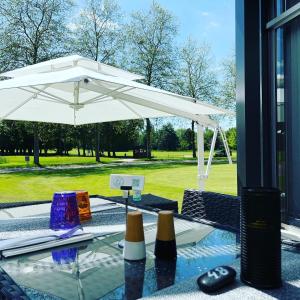 a table with a white umbrella on top of it at Hôtel du Golf Saint Lazare in Limoges