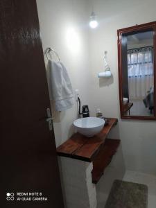 W łazience znajduje się umywalka i lustro. w obiekcie Casa Hermosa w mieście Igrejinha