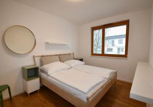 a bedroom with a bed with a mirror and a window at EFI Residence Holzova 28 in Brno