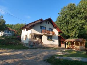 a white house with a balcony and a yard at Casa Happy Family Bran in Bran