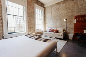 a bedroom with a bed and a brick wall at Catahoula Hotel New Orleans in New Orleans