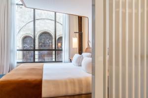 a bedroom with a large bed with a large window at Five Seas by Inwood Hotels in Cannes
