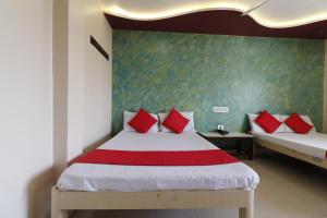 HiriyūrNEW HOTEL SURYA LODGE的一间卧室配有两张带红色枕头的床