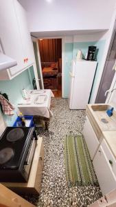 een kleine keuken met een fornuis en een koelkast bij Little Chill in Athene