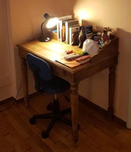 een houten bureau met een stoel en een lamp erop bij Little Chill in Athene