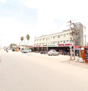 HiriyūrNEW HOTEL SURYA LODGE的街道上拥有建筑和汽车的城市街道